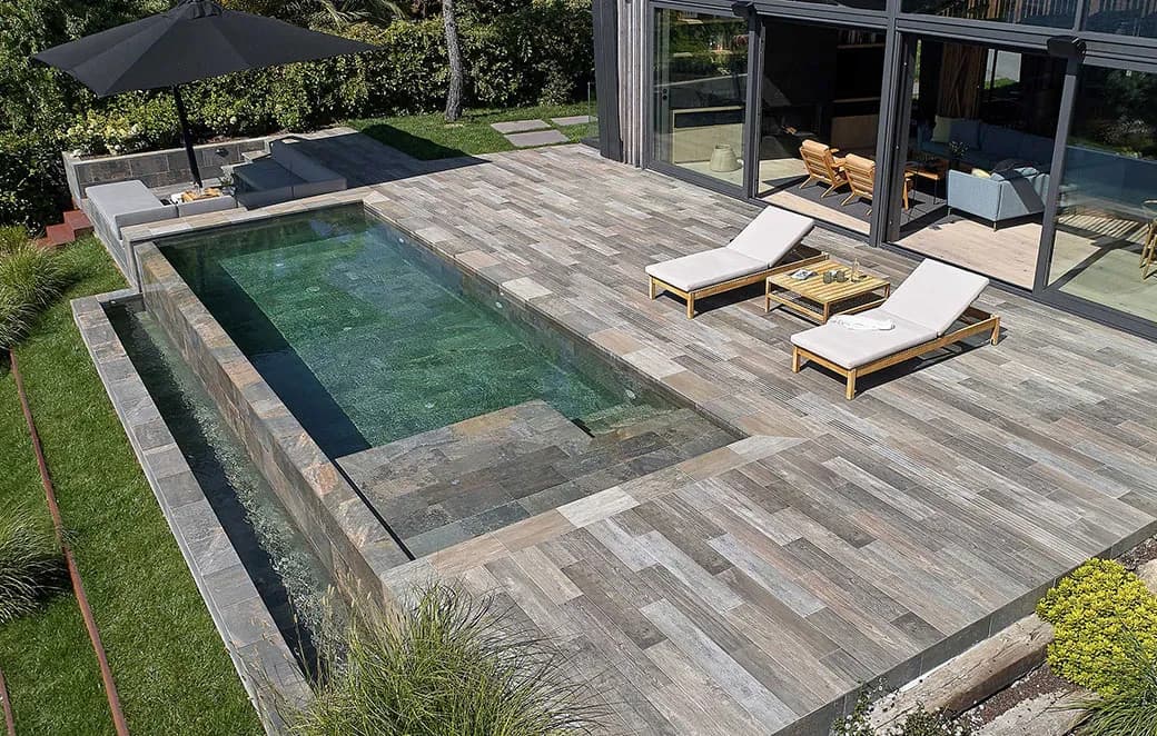 Piscina moderna con terraza exterior y zona de descanso